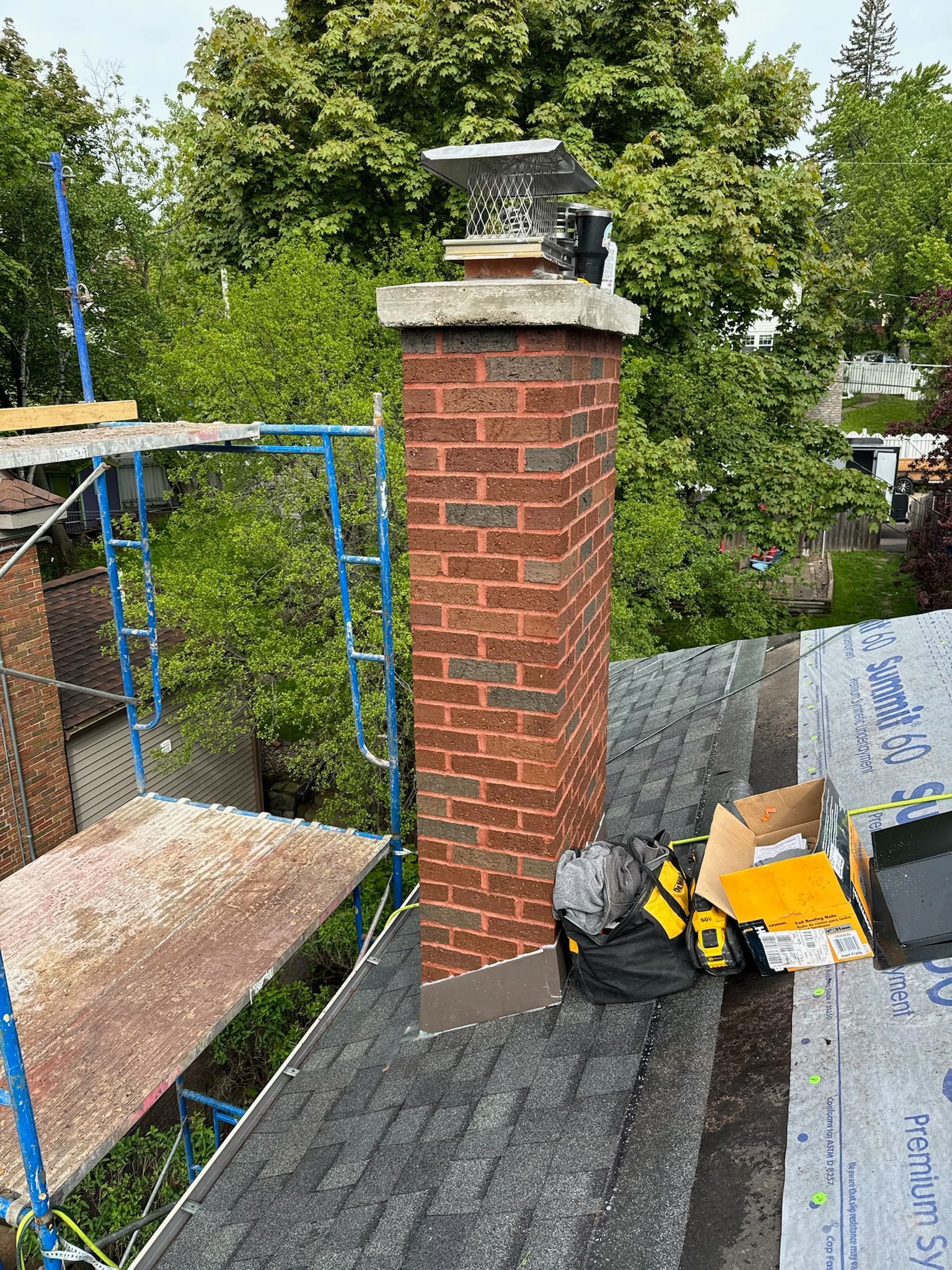 Outdoor evening scene: illuminated pool, pergola with fireplace and TV, dining table under umbrella.
