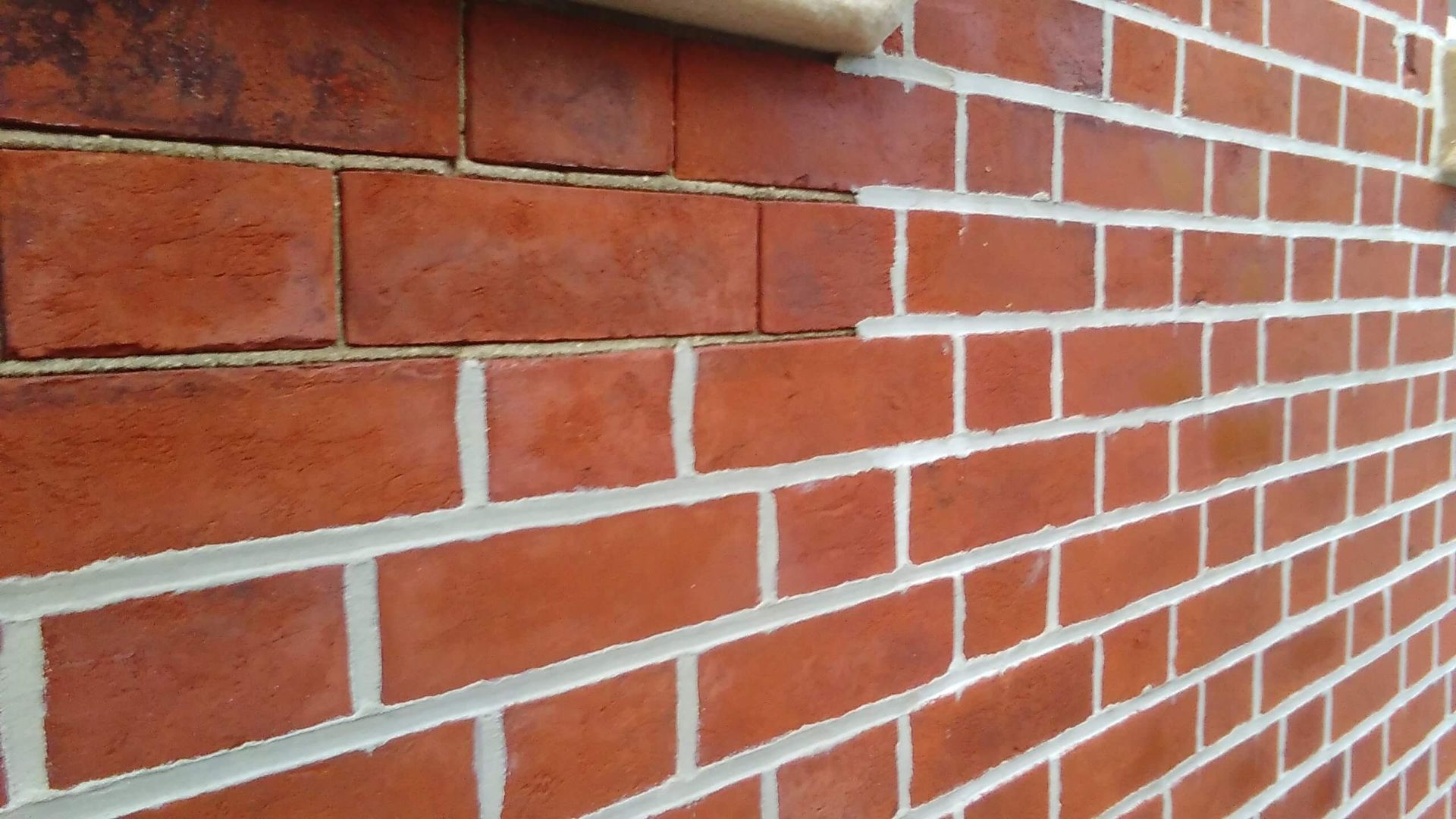 Red brick wall with white mortar. Close-up on a corner showing details of the construction.