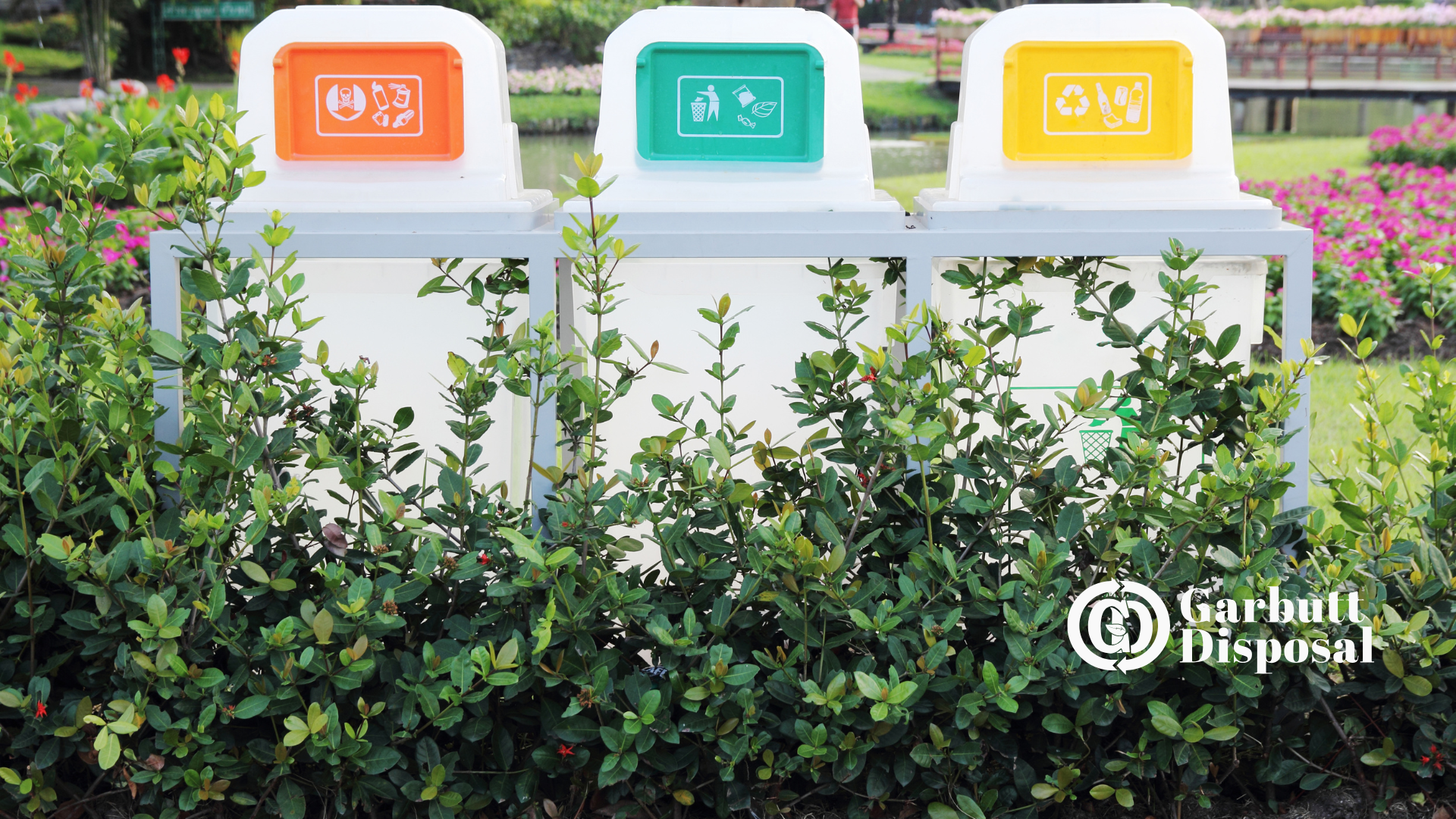 Three trash cans are sitting next to each other in a park.