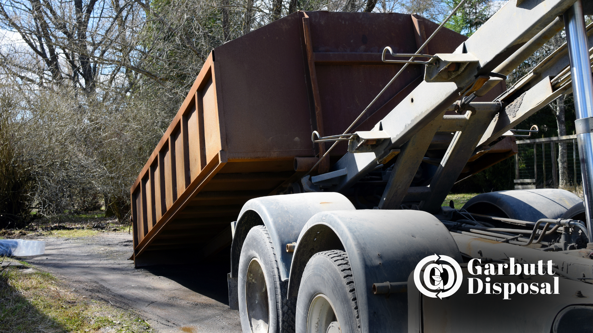 A garbage truck is parked on the side of the road.