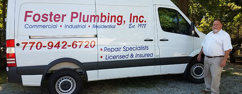 A man standing next to a foster plumbing van