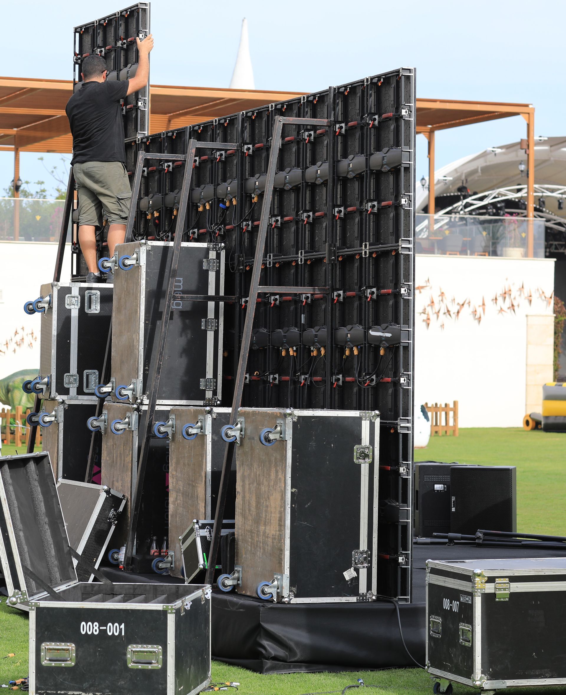 A man is standing on top of a stack of cases that say lx-x1 