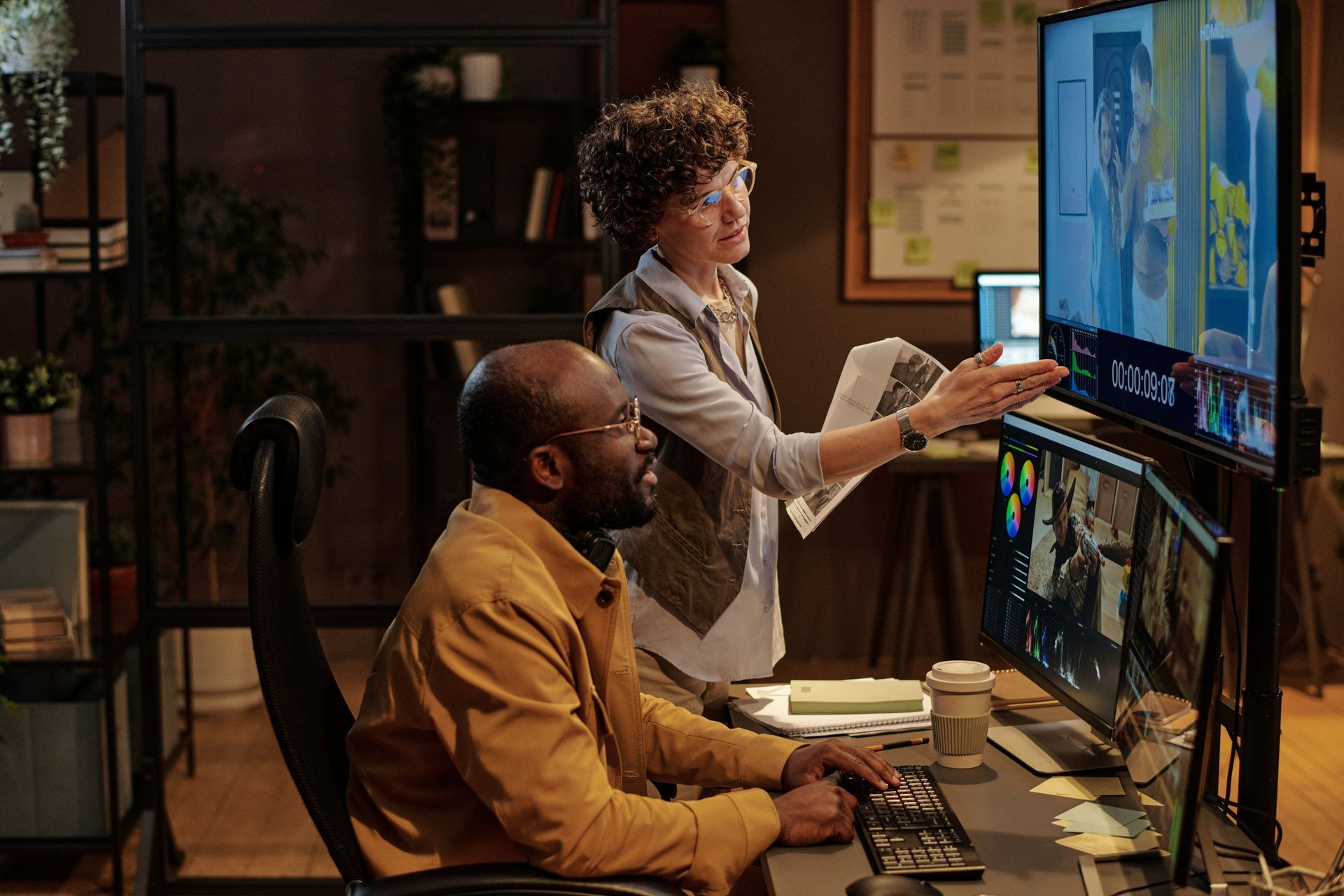 A man and a woman are looking at a computer screen. 