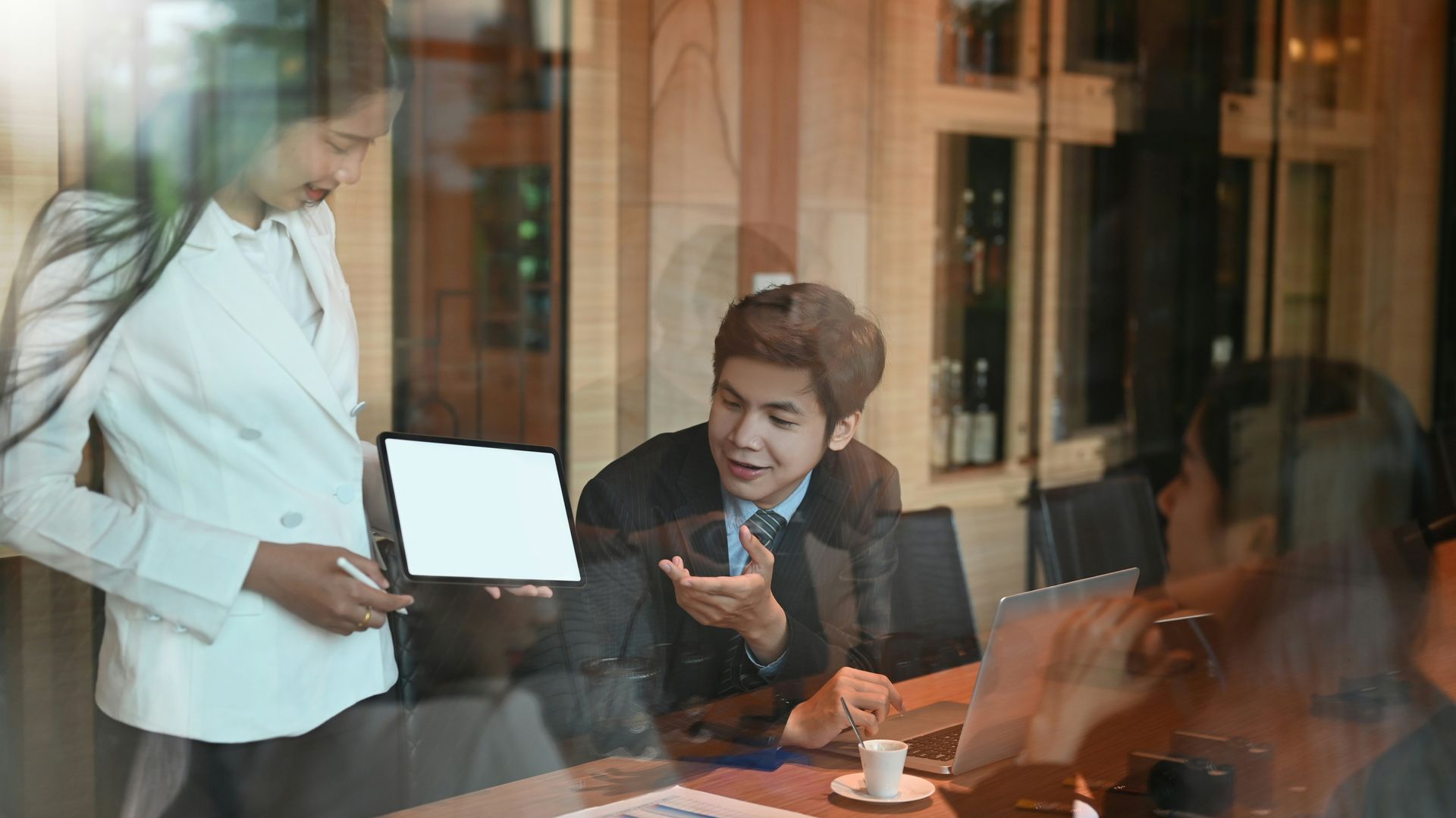 A group of business people are having a meeting in a conference room. 