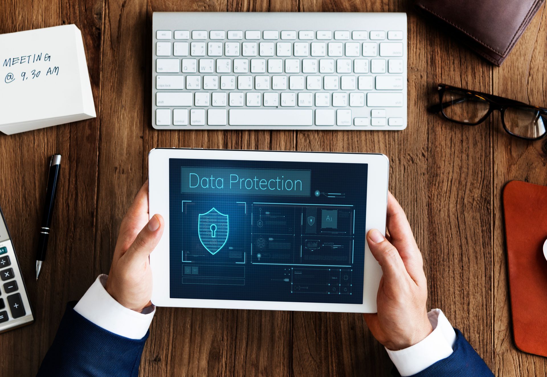 A man is holding a tablet with a screen that says data protection.  