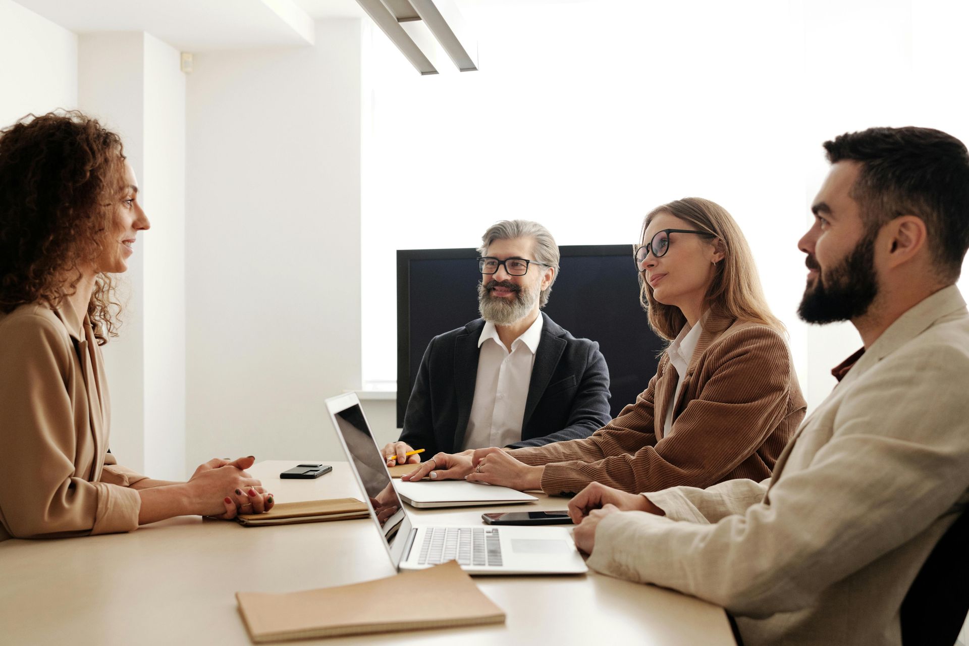 A group of people are sitting around a table having a meeting. 