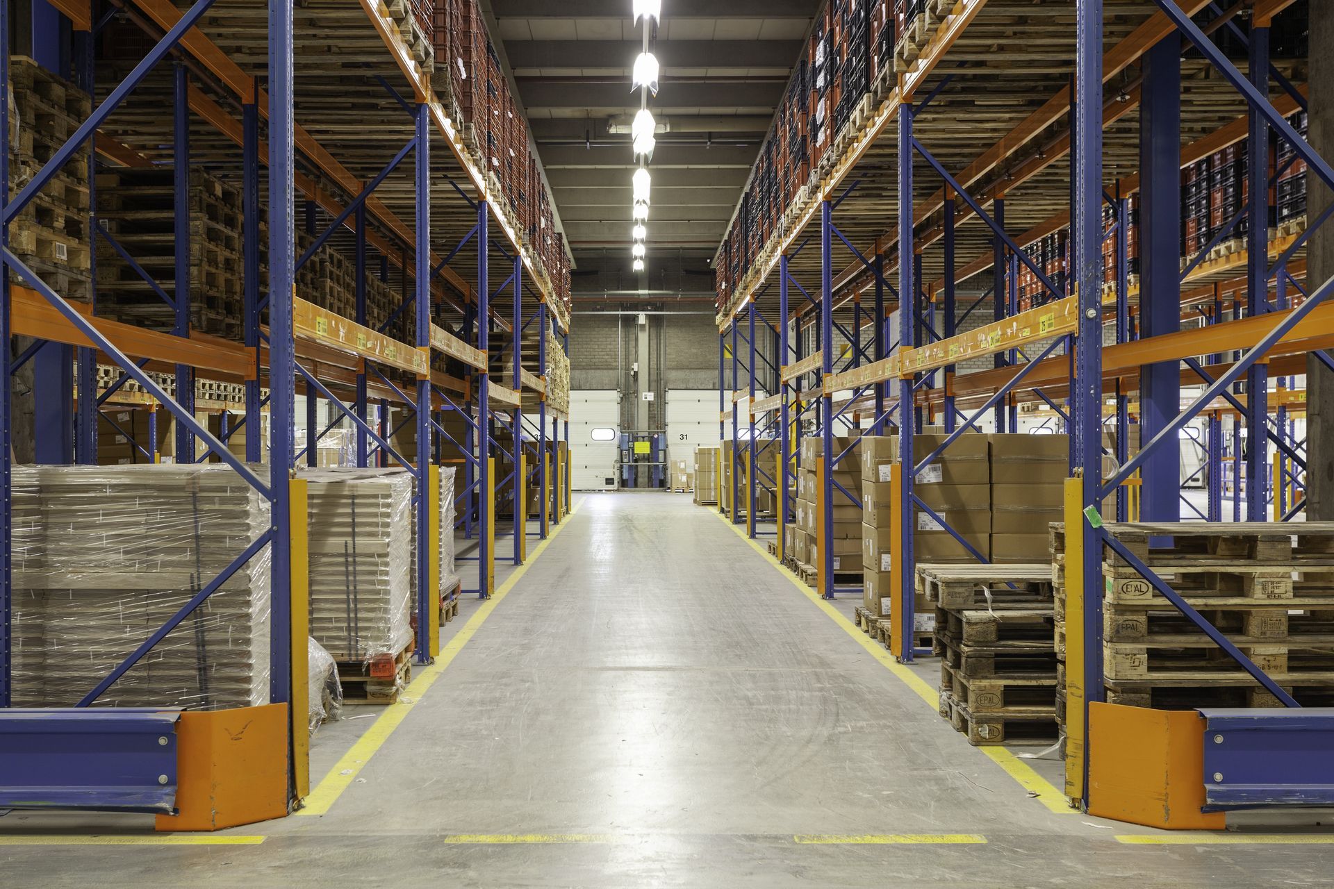 A large warehouse filled with lots of shelves and pallets. 