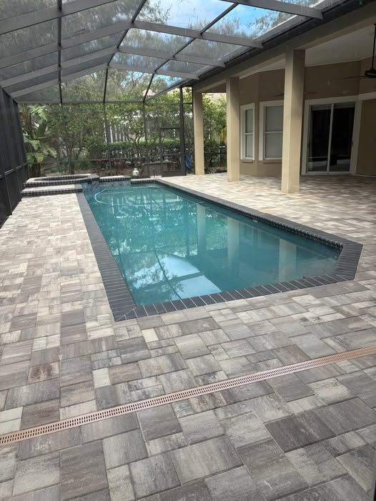 A swimming pool inside of a screen enclosure.