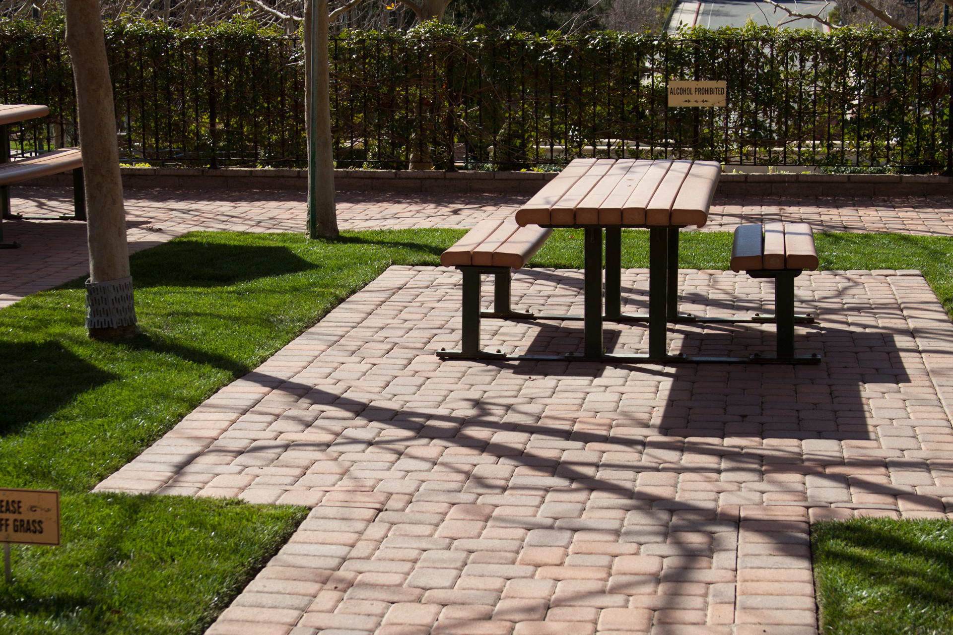 A wooden picnic table and benches in a park