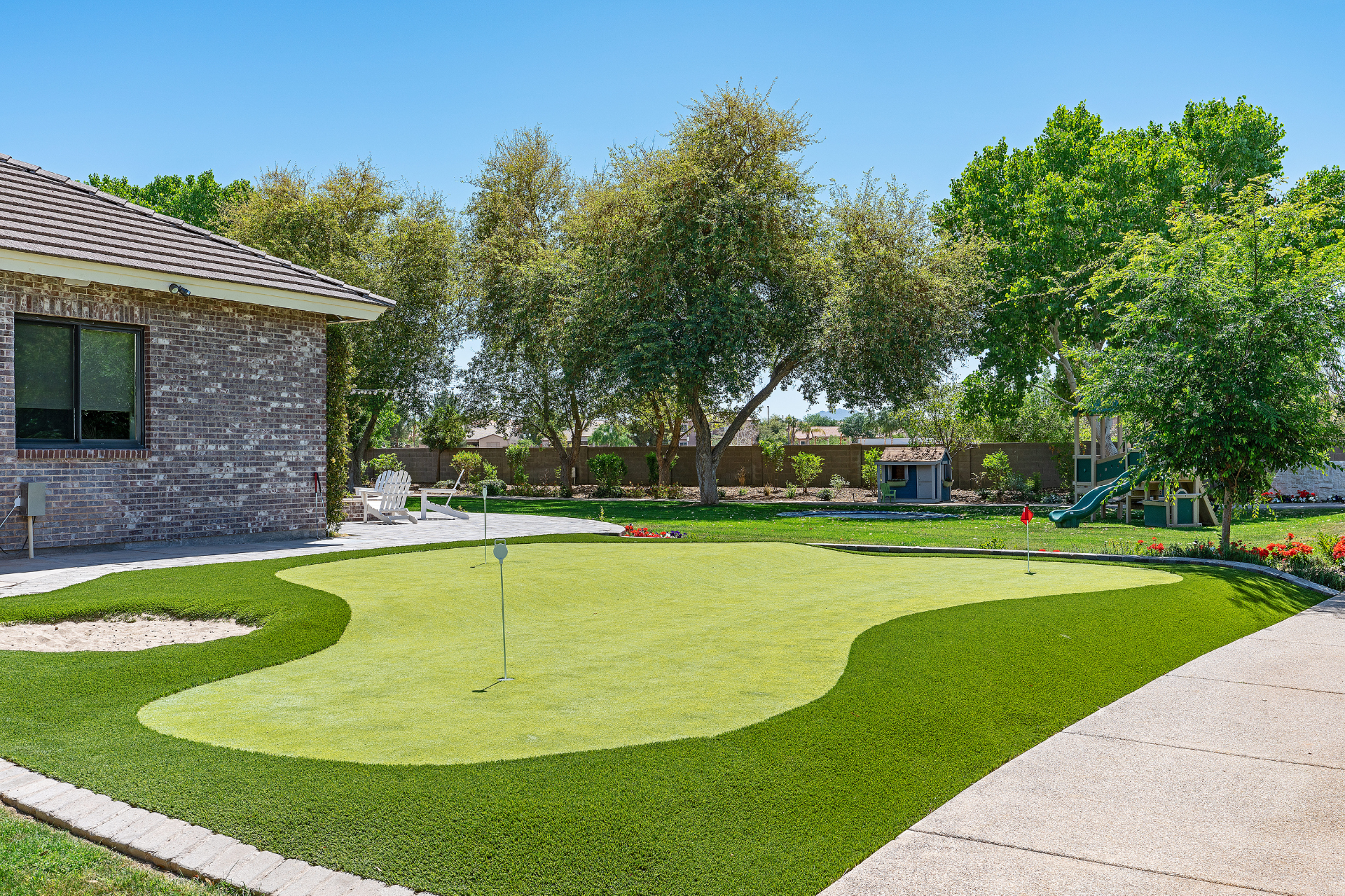 A house with a putting green in front of it