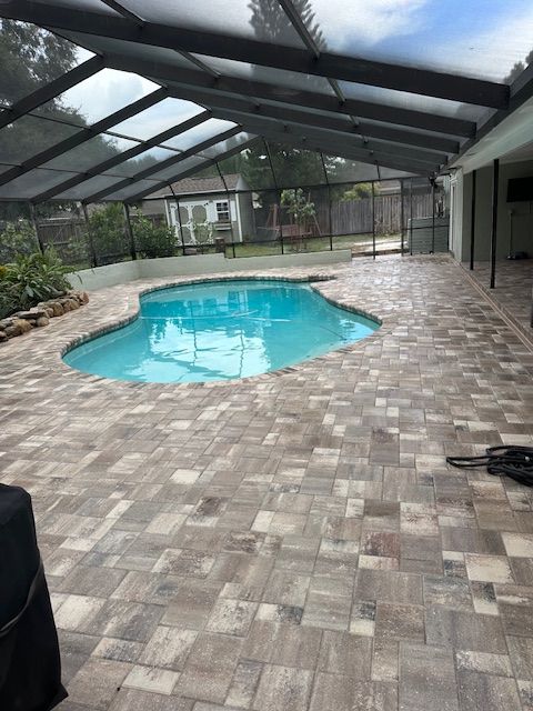 Flagstone's City Stone Demi Pavers in White/Tan/Charcoal with Coordinating White/Tan/Charcoal Coping on a Pool Deck with a Tropical Garden and Rock Feature