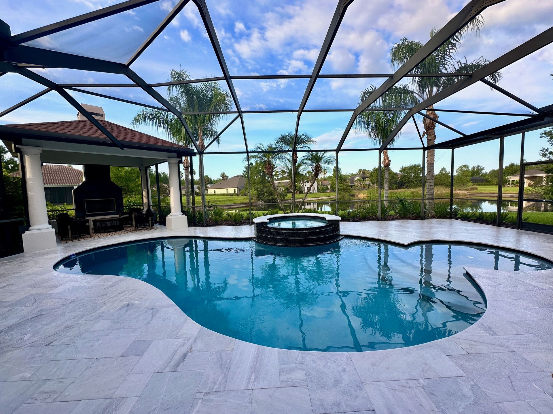 Marble pool deck with screen enclosure.