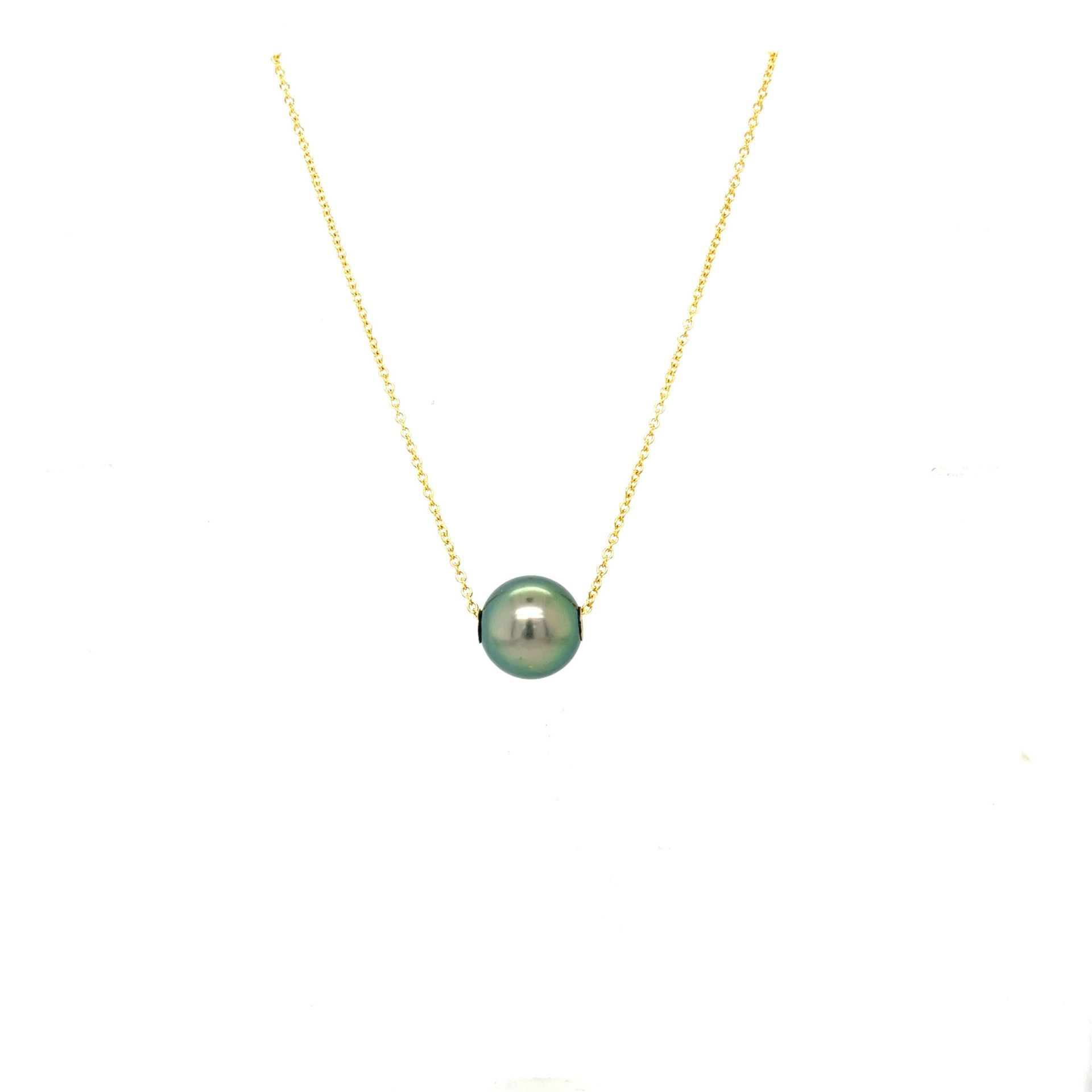 Gold chain necklace with a single green pearl pendant on a white background