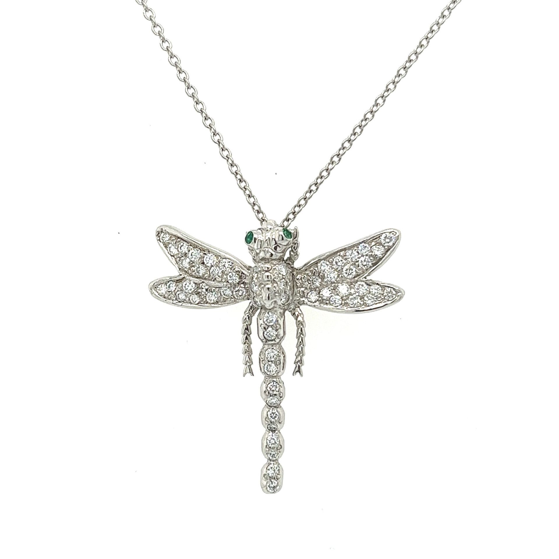 Silver dragonfly pendant necklace with sparkling stones on a white background