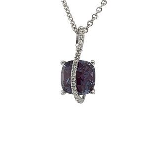 Silver necklace with a dangling dark purple gemstone pendant
