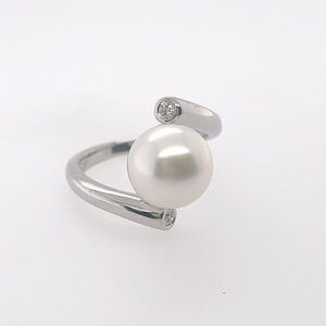 Silver ring with a large white pearl and a small crystal accent on a white background