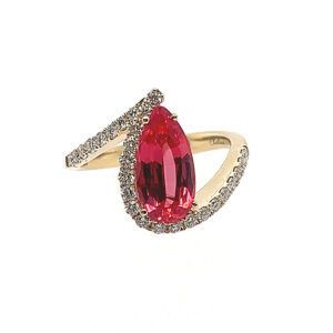 Gold ring with a large oval red gemstone and small clear stones on a white background