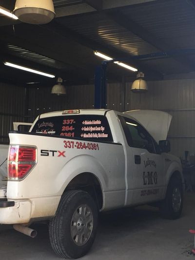 A white stx truck is parked in a garage