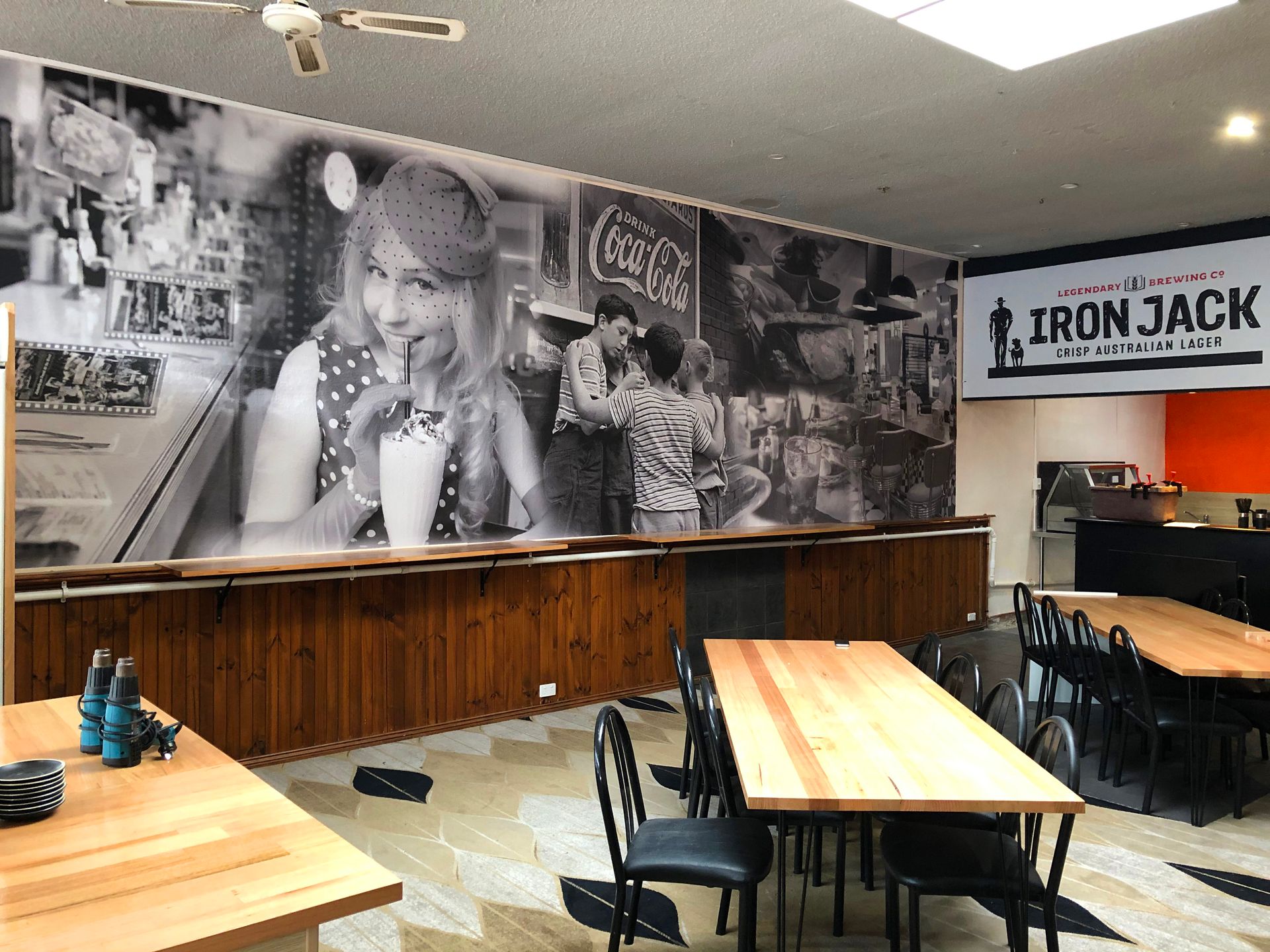 Dining area with retro mural and tables.