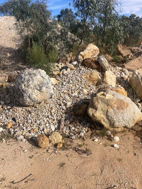 A pile of rocks sitting on top of a dirt field.
