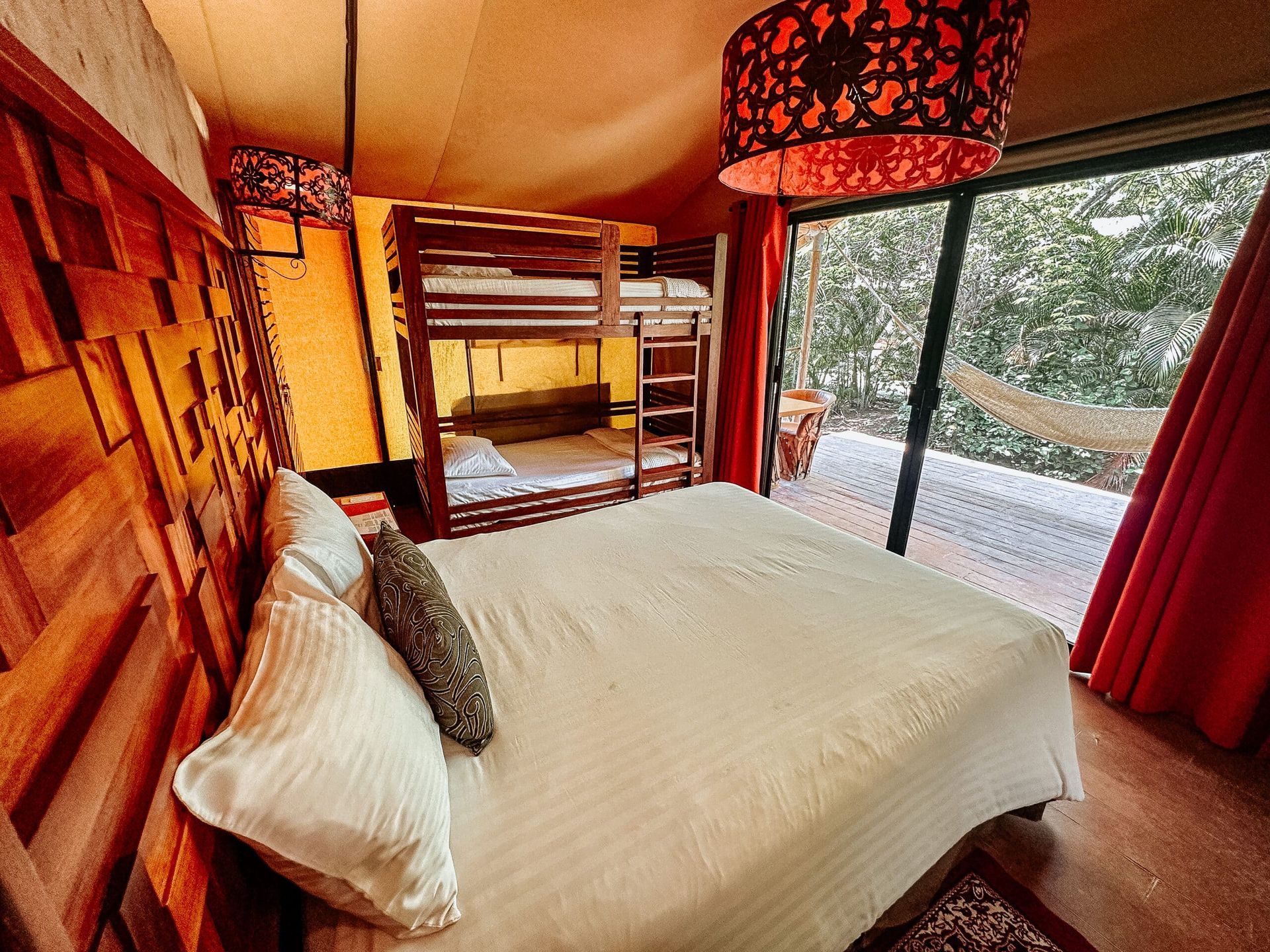 Un dormitorio con una litera y una cama grande.