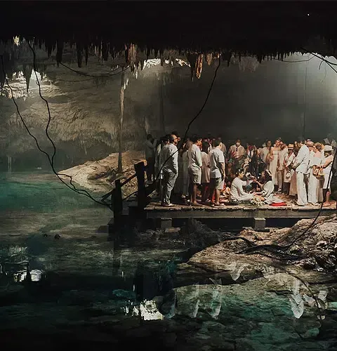 Un grupo de personas está de pie en un muelle en una cueva.