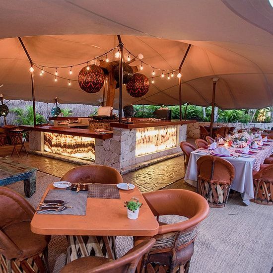 Un restaurante con mesas y sillas bajo una carpa.