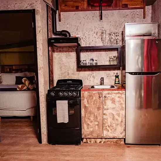 Una cocina con estufa, refrigerador, fregadero y gabinetes.
