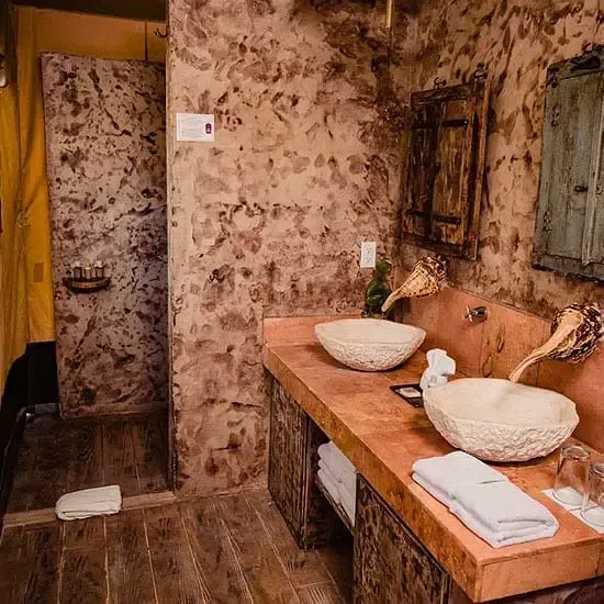 Un baño con dos lavabos y ducha.