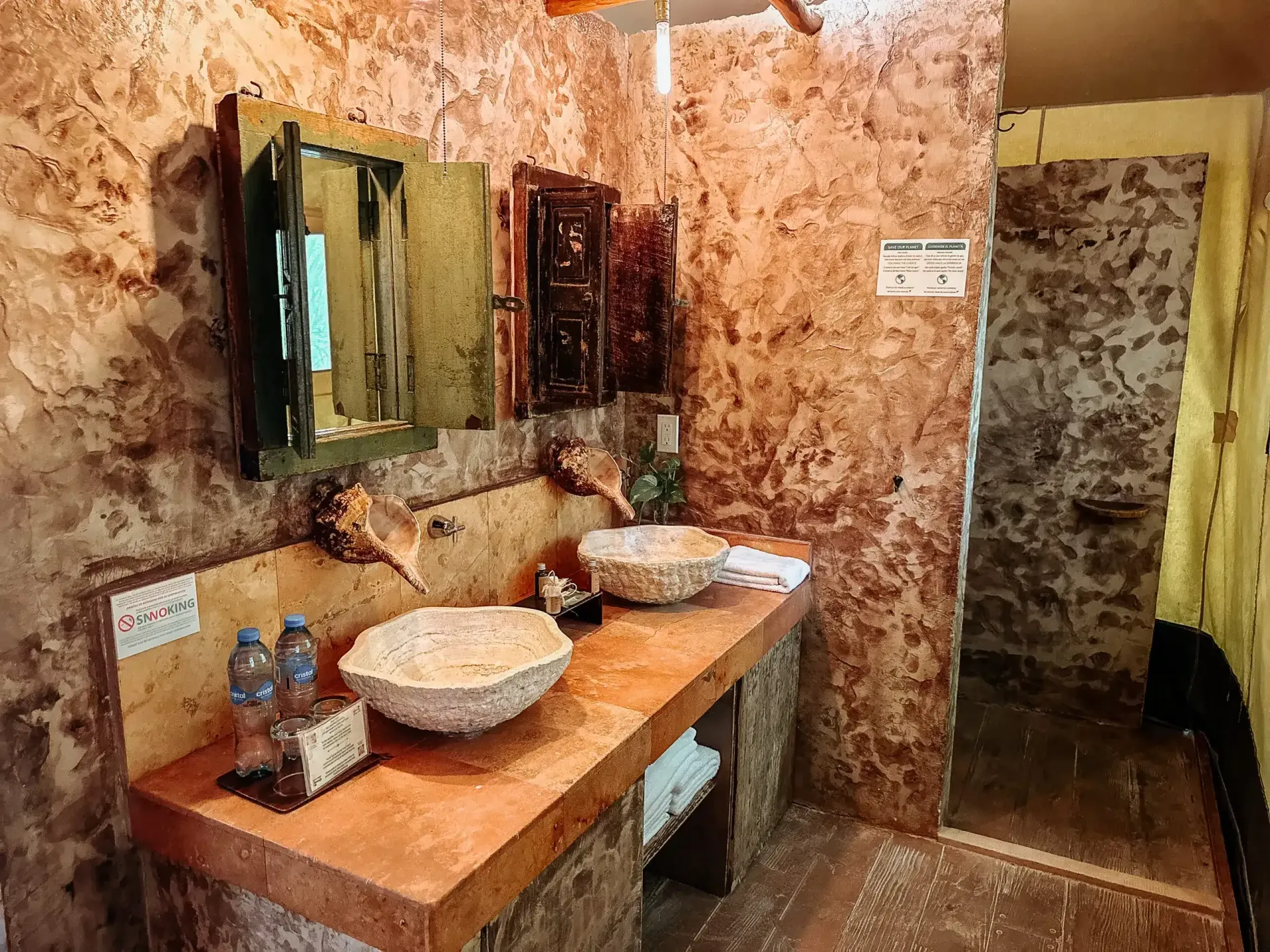 Un baño con dos lavabos, un espejo y una ducha a ras de suelo.