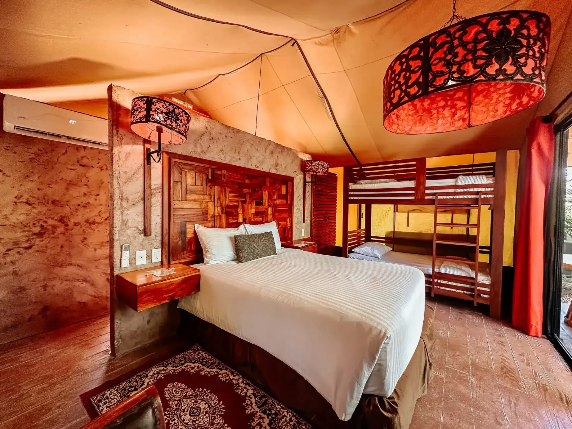 Un dormitorio con una cama king size y literas.