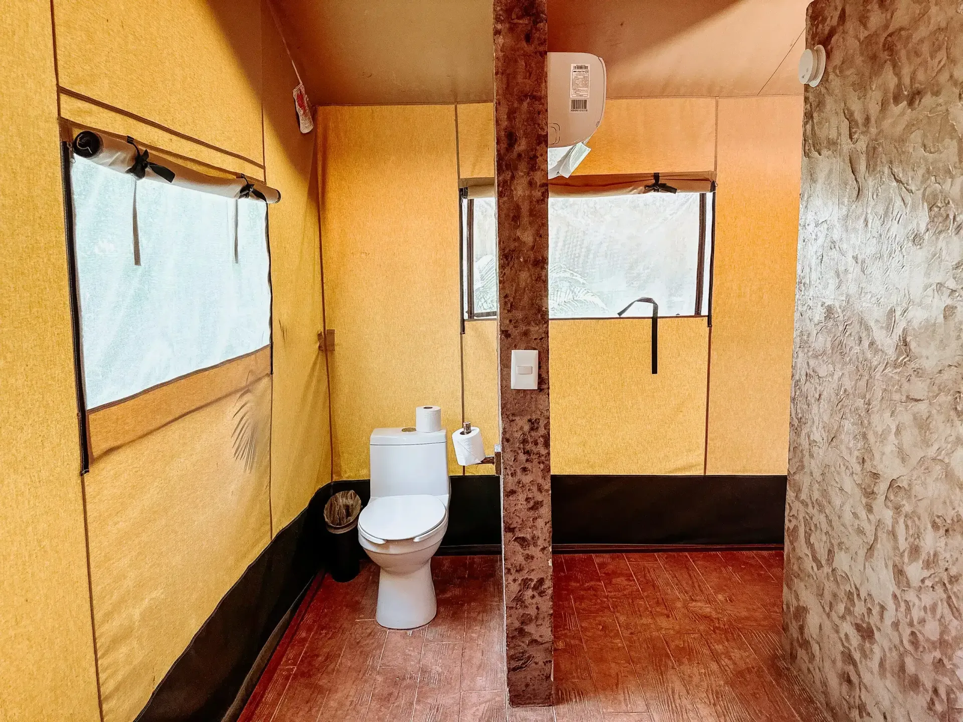 Un baño con inodoro y ventana.