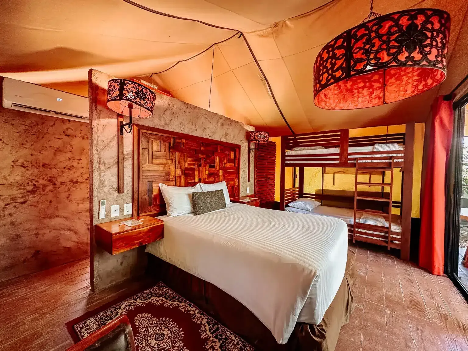 Una habitación de hotel con una cama grande y literas.