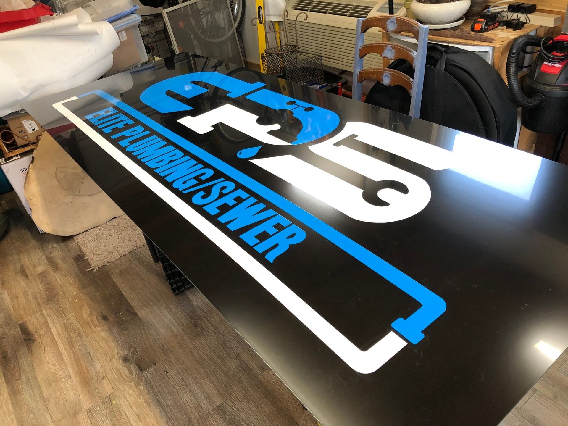 Black sign with blue and white logo: 