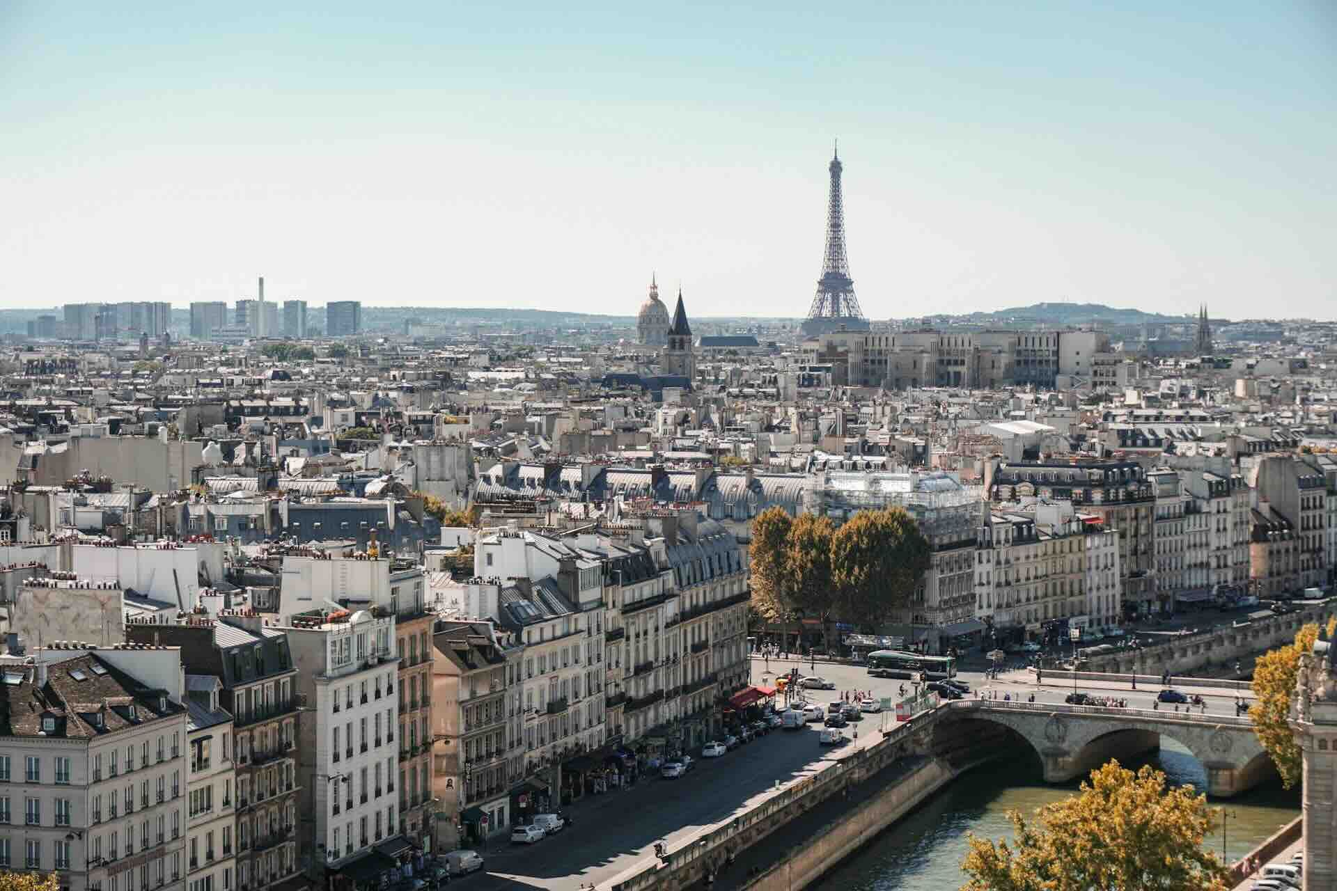 Paris cityscape, Eiffel Tower in the distance, buildings and a canal in the foreground.