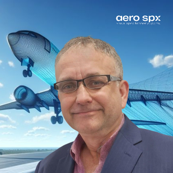 A man wearing glasses is smiling in front of an aero spx logo