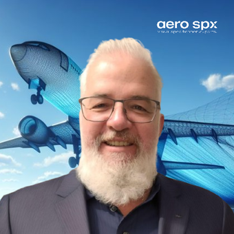 A man with glasses and a beard is smiling in front of an aero spx logo