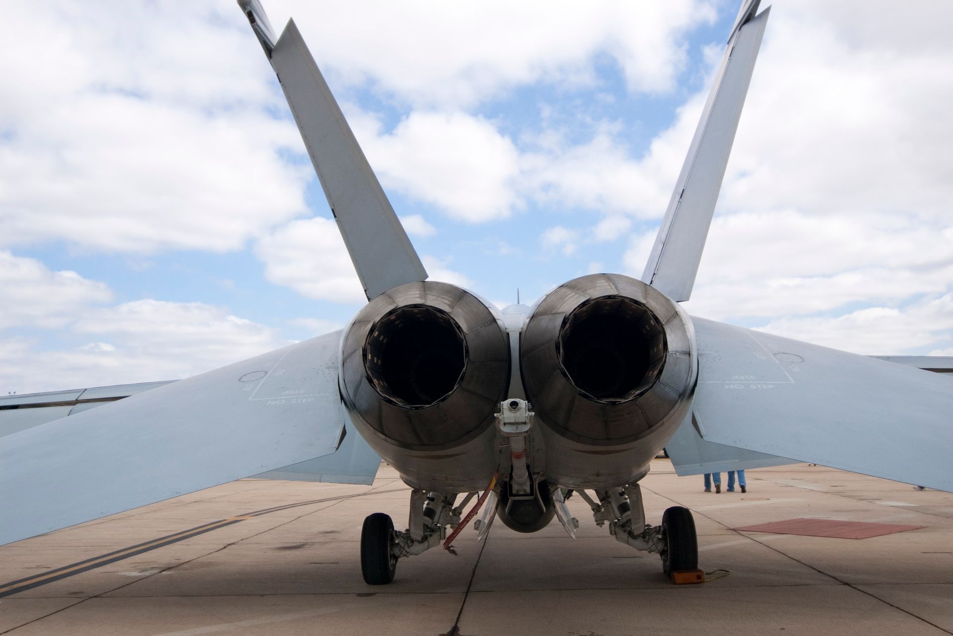 A fighter jet is parked on a runway with its wings outstretched