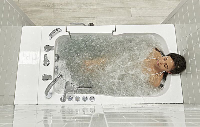 A woman is laying in a bathtub filled with water