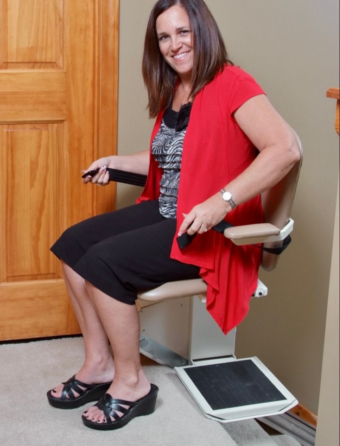 A woman in a red jacket is sitting on a chair