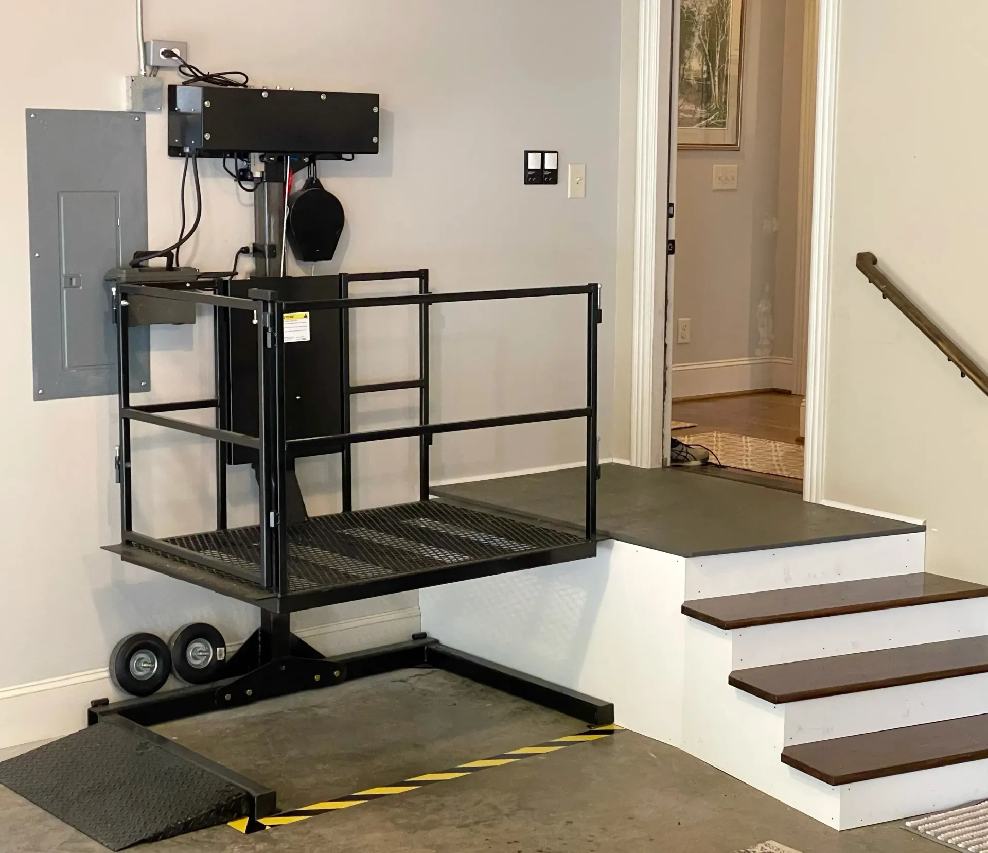 A stair lift is in a room next to the stairs