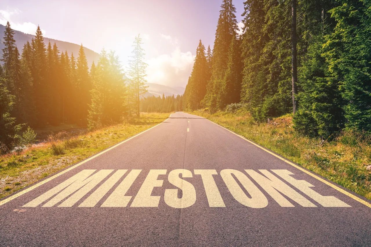 The word milestone is painted on the side of a road.