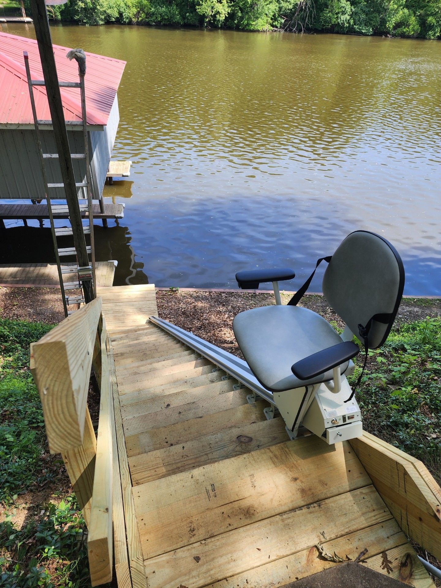 A chair is sitting on a wooden deck next to a body of water.