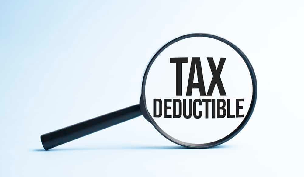 A magnifying glass with the word tax deductible on it.