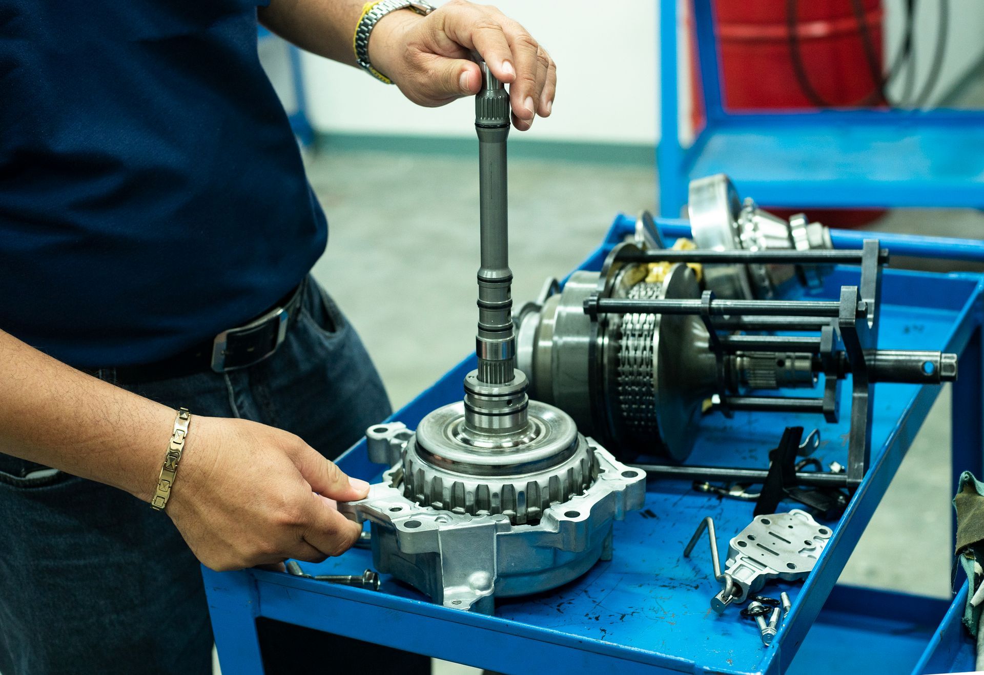 A close-up of a mechanic’s hand working on a car gearbox automotive repair in a workshop. A close-up of a mechanic’s hand working on a car gearbox automotive repair in a workshop.