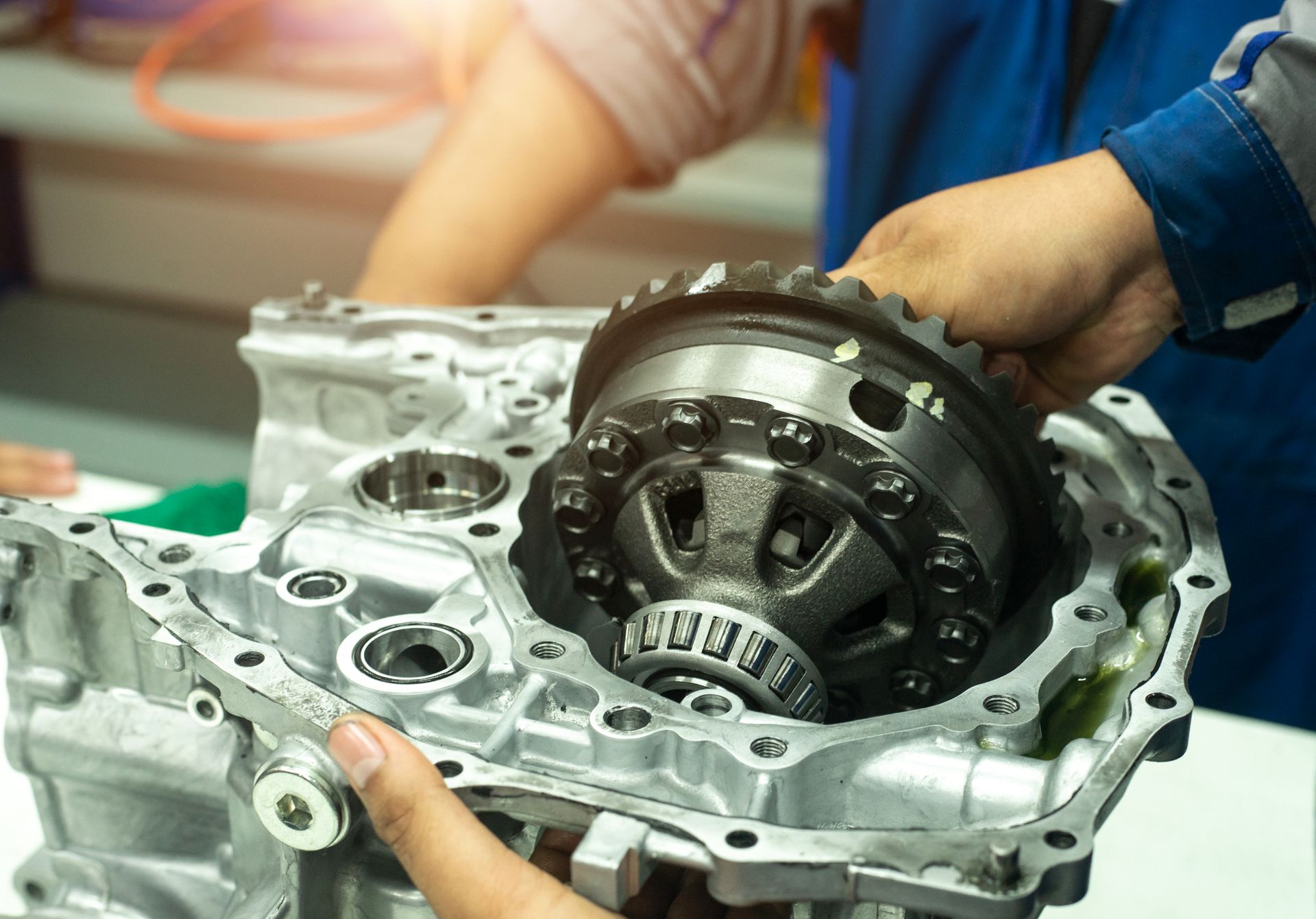 A close-up of a mechanic’s hand working on a car gearbox automotive repair.