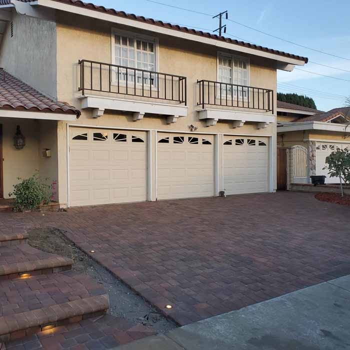 A house with three garage doors and a balcony