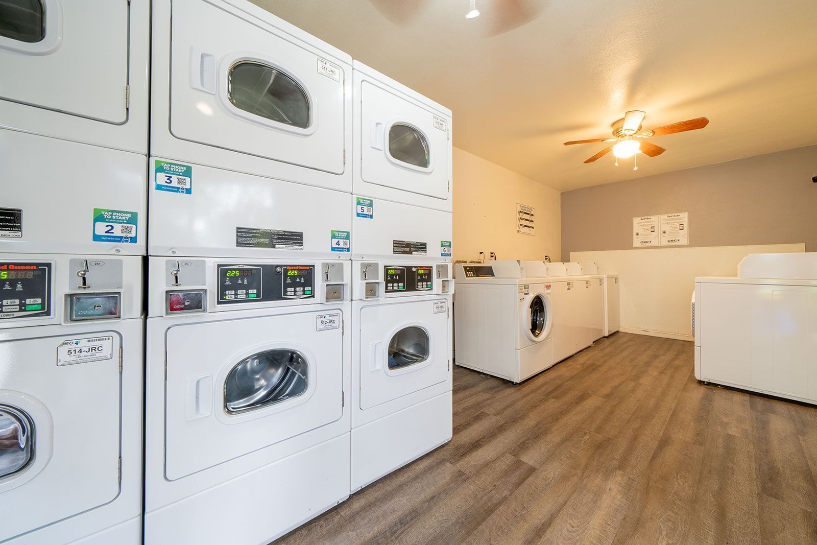 A laundromat with a lot of washers and dryers stacked on top of each other.
