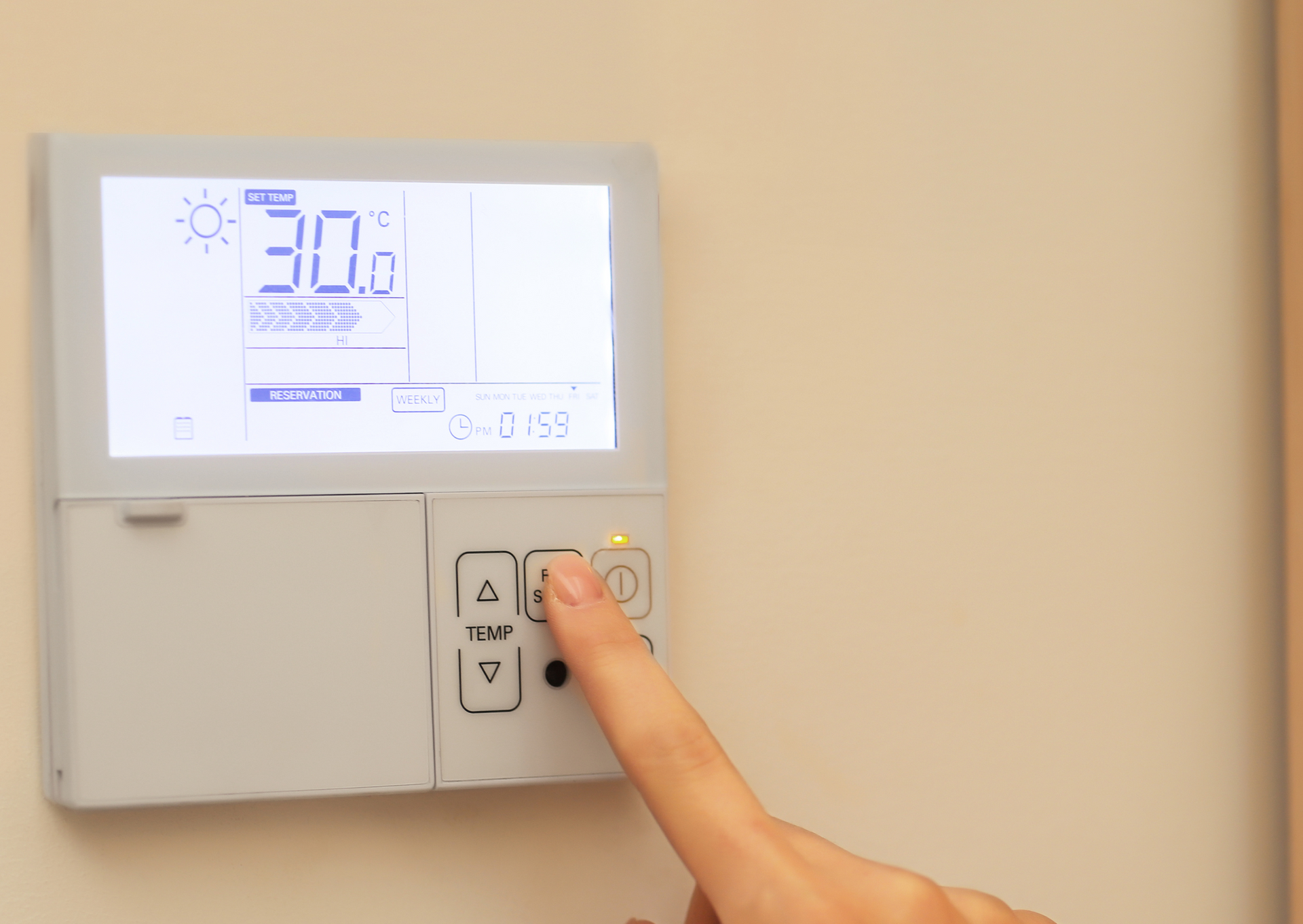 Person adjusting a thermostat, set to 30 degrees Celsius, with a finger on an up arrow button.