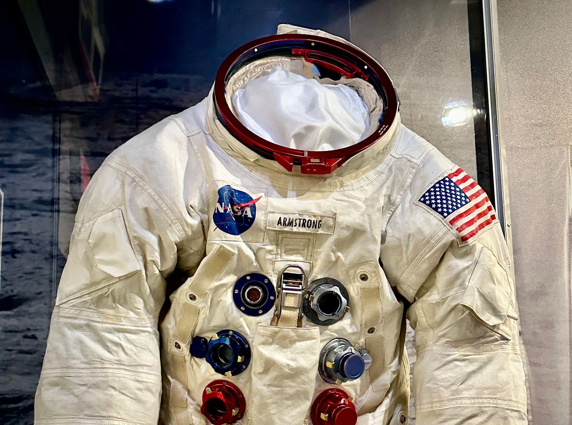 A NASA space suit is displayed in a glass case.